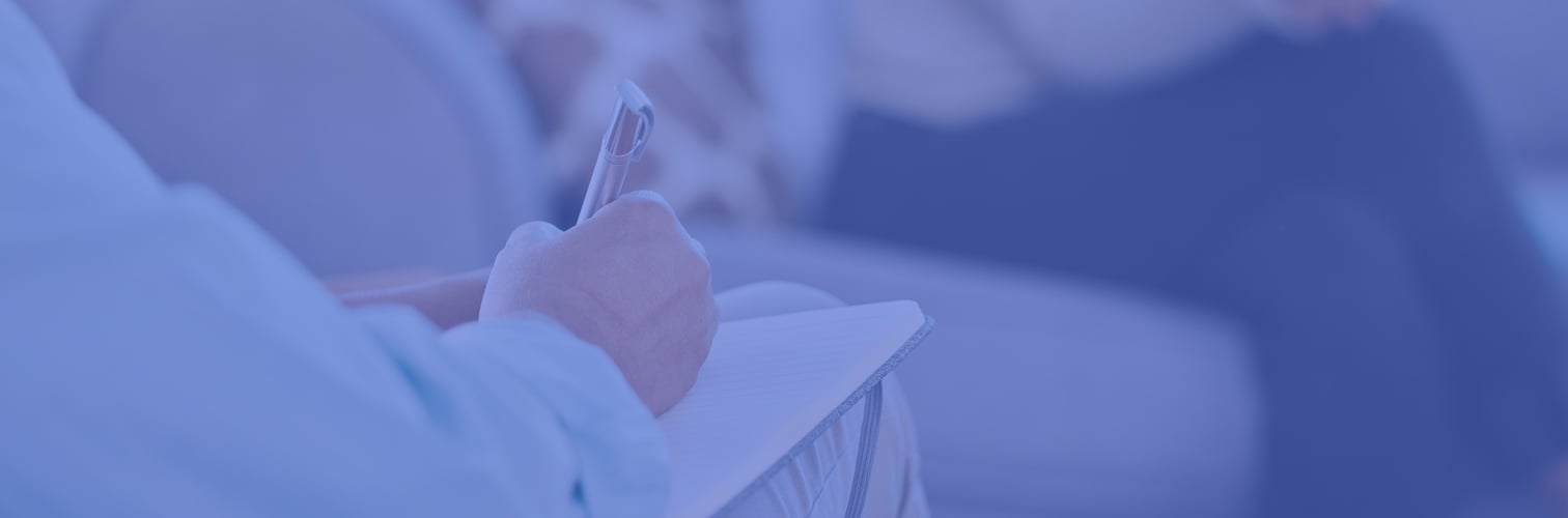 A photo showing a therapist taking notes during a therapy session, which is normal in the behavioral health care system but can hinder patient satisfaction and ultimately impact health outcomes