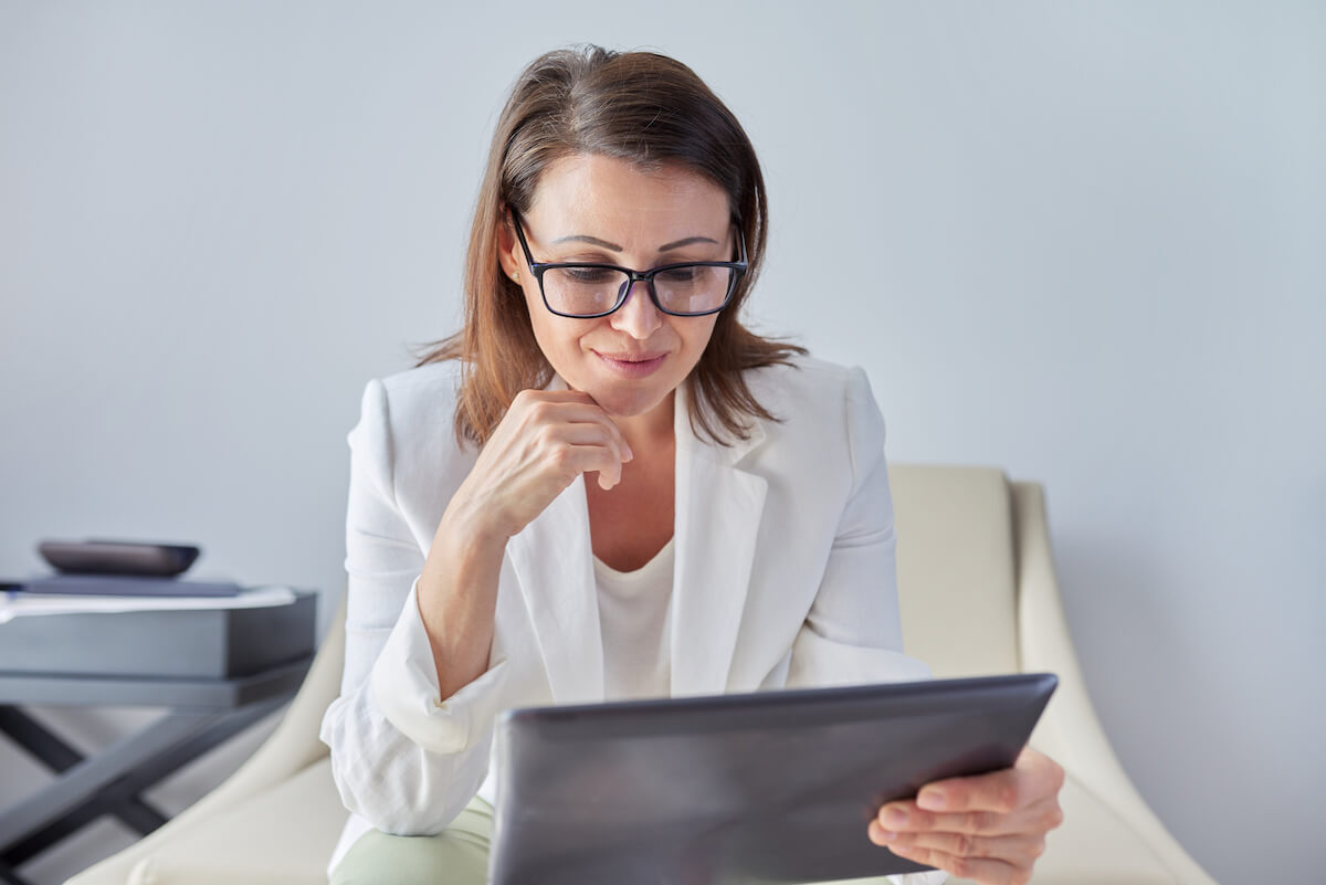 woman sitting at computer comparing electronic medical records vs electronic health records definitions in regards to healthcare organizations